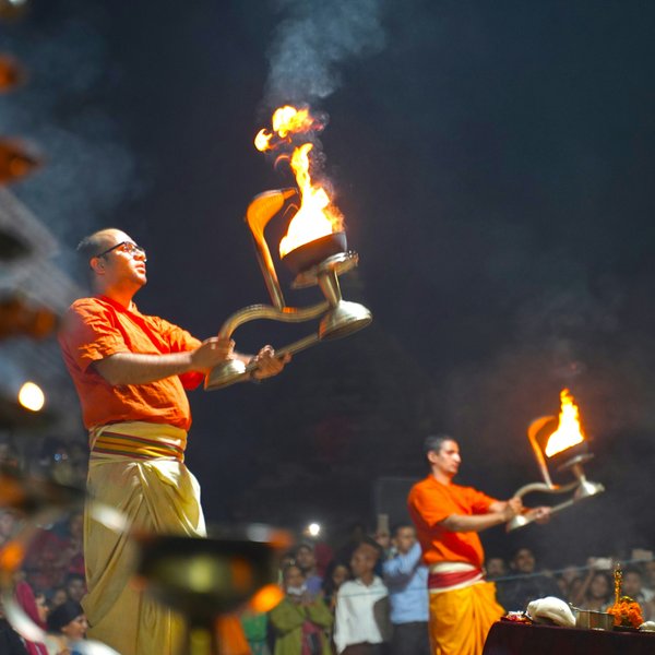 Evening Hindu Aarti ceremony with priests holding fire lamps at Pashupatinath Temple in Kathmandu.