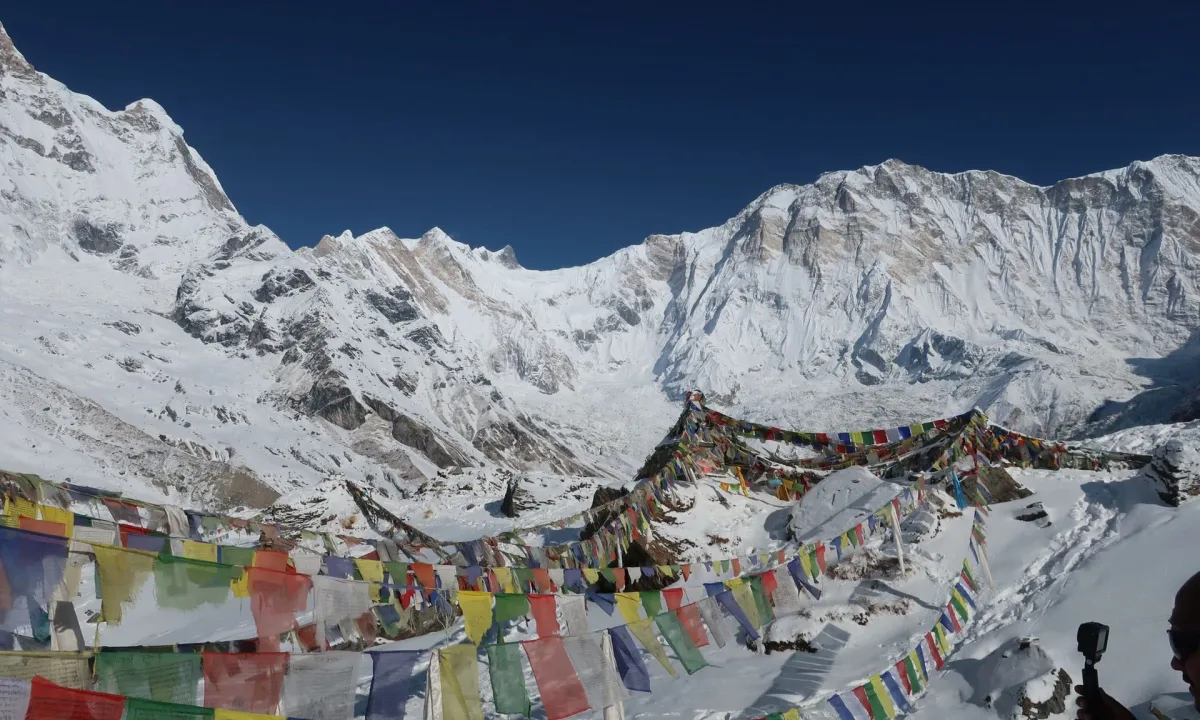 Prayer flags flutter against snow-covered Annapurna mountains in Nepal.