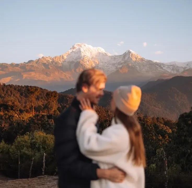 Couple trekkers watching Annapurna South golden sunrise Australian Camp Annapurna foothills Nepal