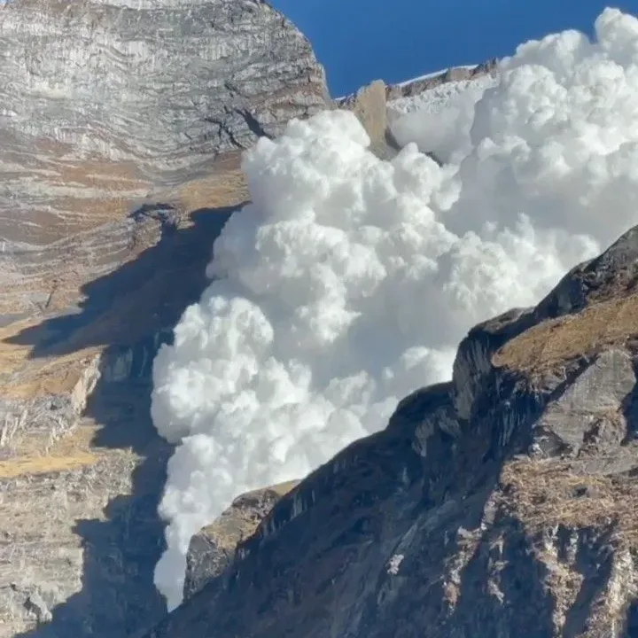 Avalanche snow cloud crashing down Himalayan mountain face Kapuche Lake trek Annapurna Nepal