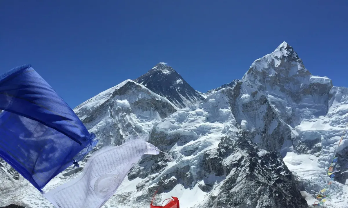 Mount Everest and Lhotse peaks rising above Khumbu glacier with prayer flags in foreground, Nepal Himalaya