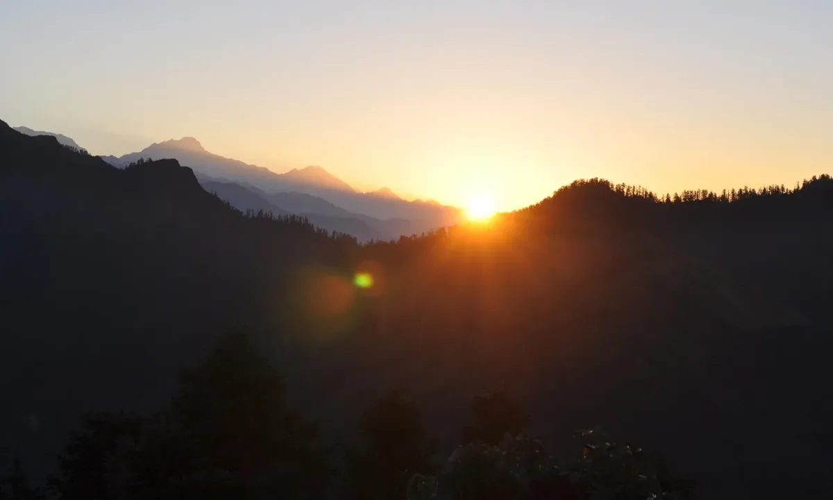 Golden sunrise over layered dark Himalayan ridgelines viewed from Khopra Danda ridge, Annapurna region Nepal