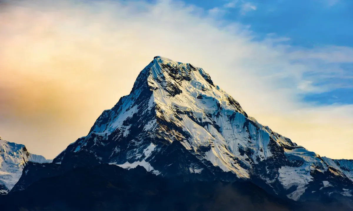 Machhapuchhre Fishtail mountain glowing golden against dramatic sunset sky on Khopra Ridge trek, Annapurna Nepal