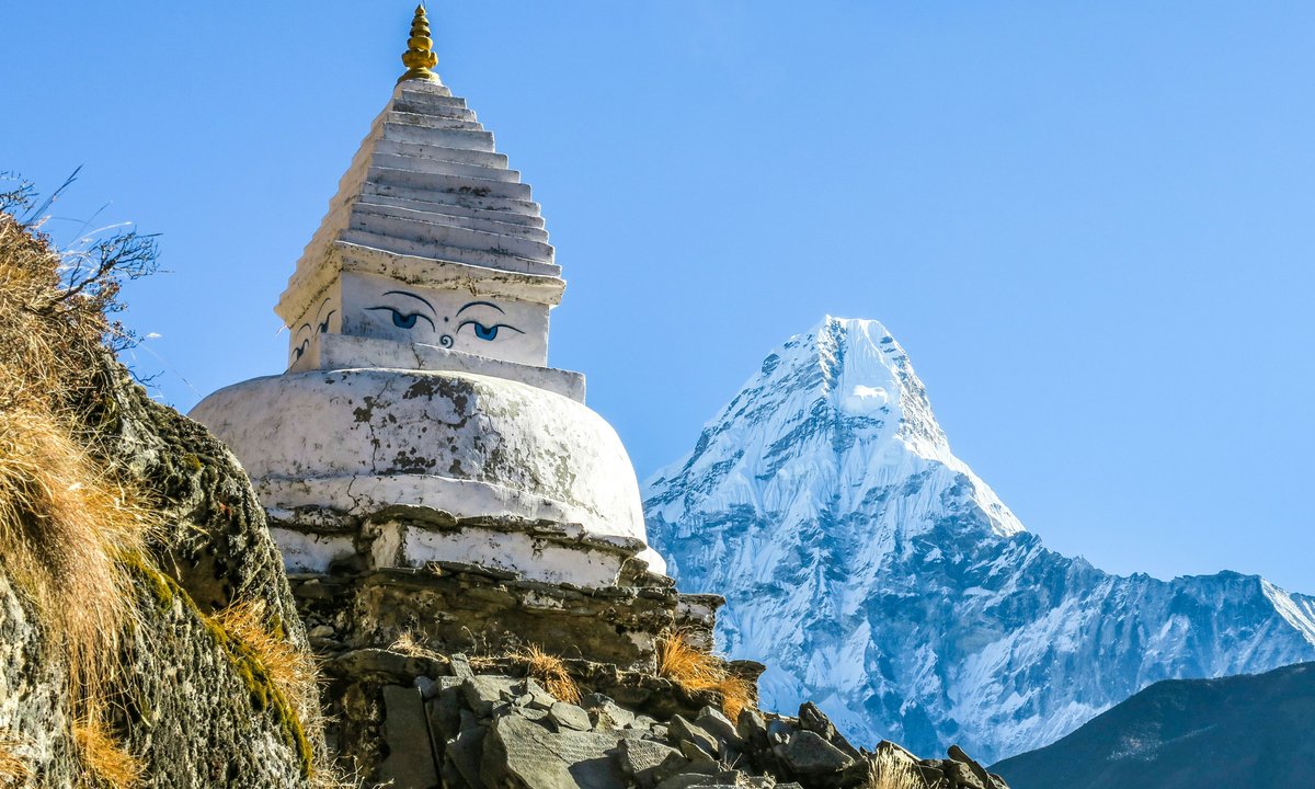 Buddhist stupa along the Everest Base Camp trekking trail with snow-capped Ama Dablam peak in the background, Khumbu region Nepal