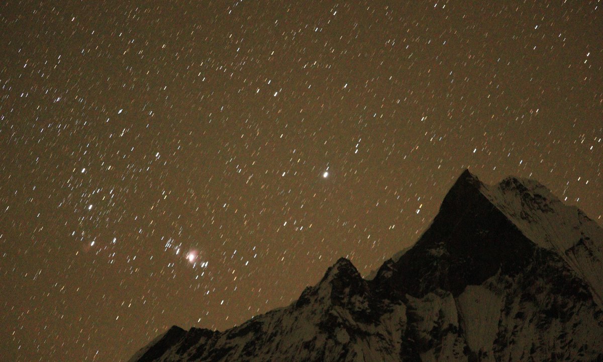 Milky Way and stars above snow-capped Himalayan peaks in the Annapurna Sanctuary