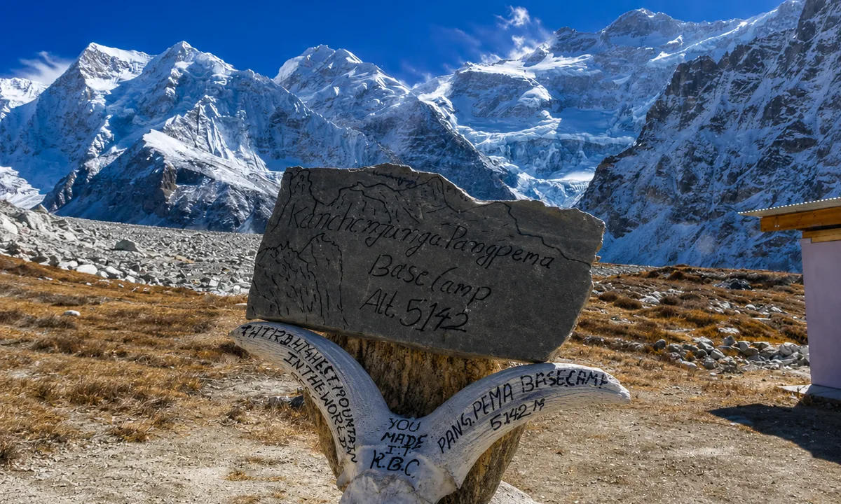  Mani prayer stone, Tibetan inscriptions, Kanchenjunga peaks behind  Tibetan mani prayer stone with inscriptions and Kanchenjunga snow peaks in background eastern Nepal