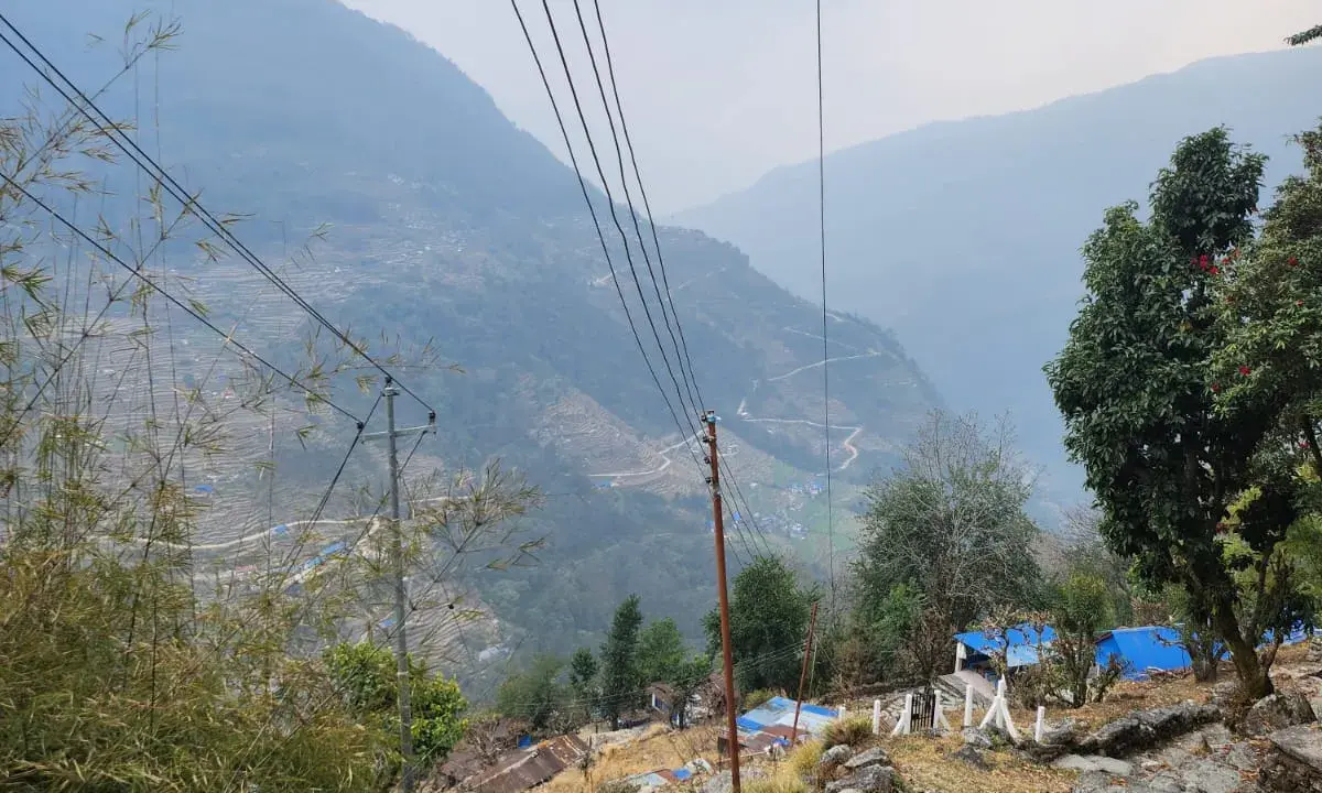  View down into the Annapurna foothills valley from the Ulleri trail showing terraced fields and a winding mountain road, Nepal