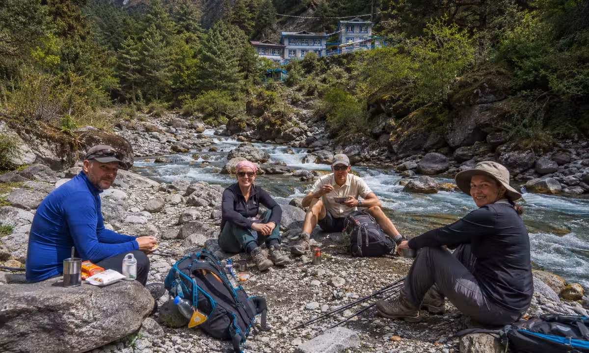 Trekkers resting for tea and lunch beside the Kharikhola river on the Everest Base Camp trail below Lukla, Nepal