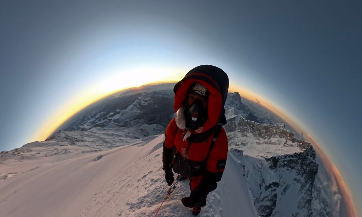 Sudhigya Pant at high altitude on Everest with the visible curvature of the earth and a golden sunrise on the horizon — the view he says no words can describe