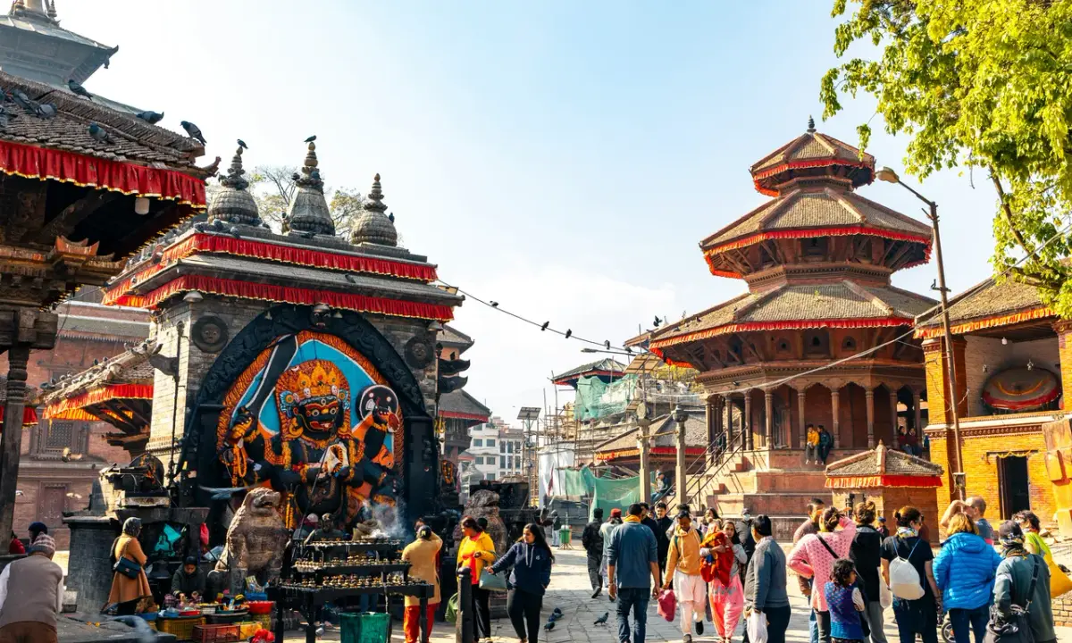 Crowds at Kathmandu Durbar Square near the colorful Kala Bhairav statue and octagonal Chyasin Dega temple.