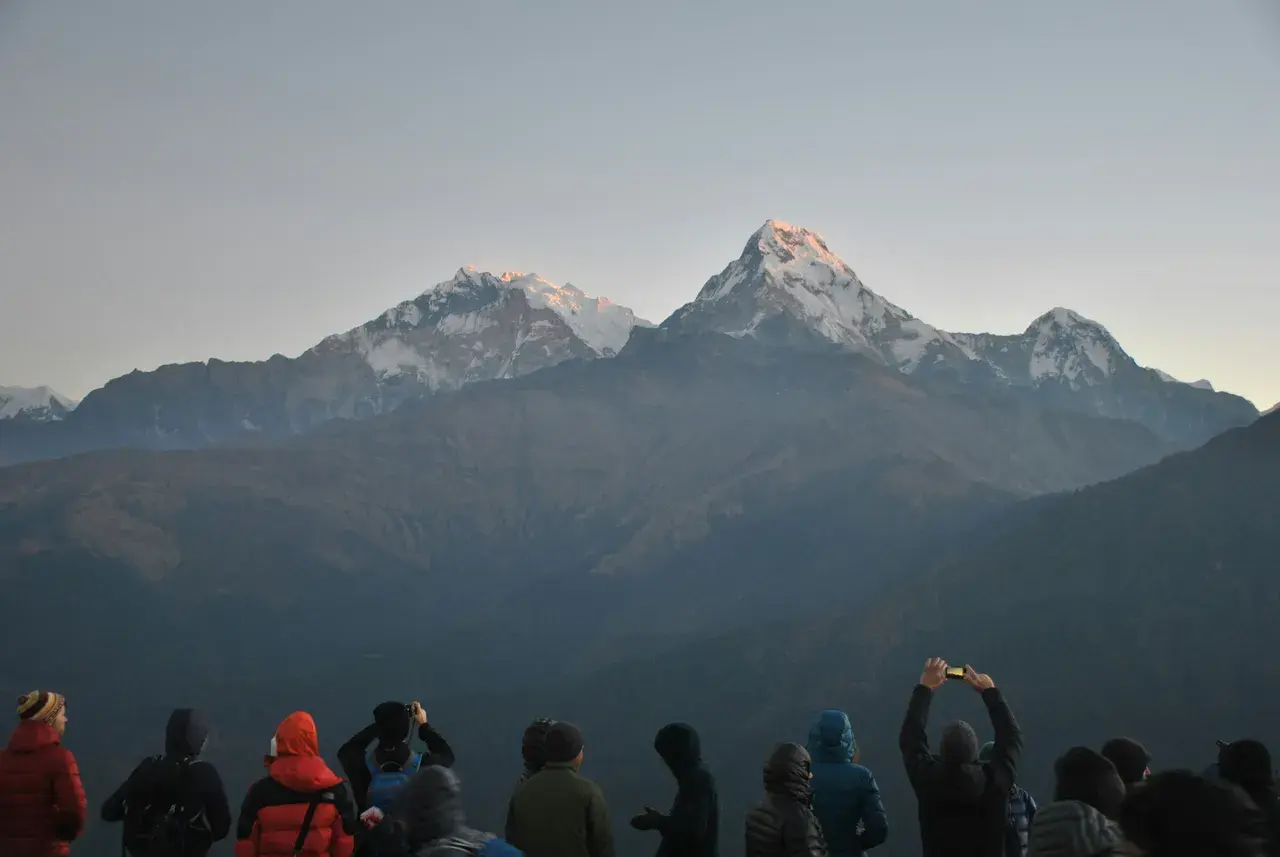 Trekkers watching sunrise over Annapurna and Machapuchare from Poon Hill 3210m Ghorepani Nepal