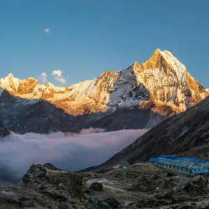 Annapurna Base Camp lodges nestled in the Himalayas, bathed in golden sunrise light.
