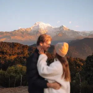 Couple trekkers watching Annapurna South golden sunrise Australian Camp Annapurna foothills Nepal