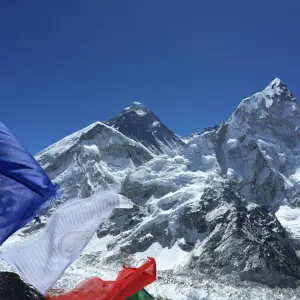 Mount Everest and Lhotse peaks rising above Khumbu glacier with prayer flags in foreground, Nepal Himalaya