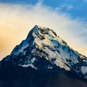 Machhapuchhre Fishtail mountain glowing golden against dramatic sunset sky on Khopra Ridge trek, Annapurna Nepal