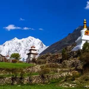 Ancient Buddhist stupa with snow-capped Manaslu peaks, Manaslu fastpacking route Nepal