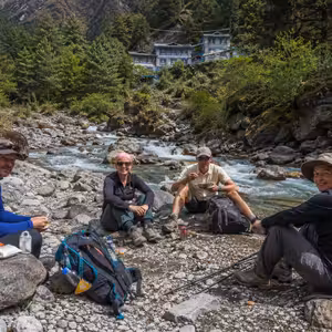 Trekkers resting for tea and lunch beside the Kharikhola river on the Everest Base Camp trail below Lukla, Nepal