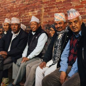 Group of Nepali men in traditional dhaka topi sitting together, representing the diverse ethnic communities of Nepal