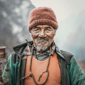 Sherpa elder holding a traditional Buddhist prayer wheel in the Everest region of the Khumbu valley, Nepal