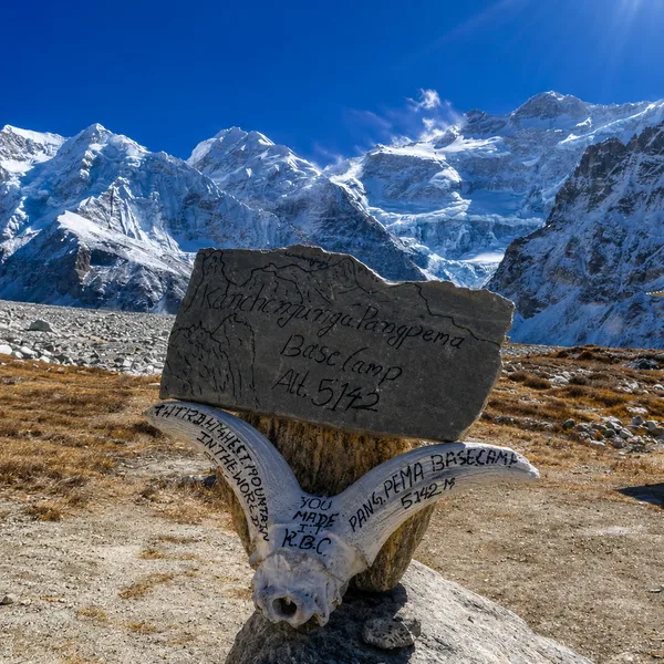  Mani prayer stone, Tibetan inscriptions, Kanchenjunga peaks behind  Tibetan mani prayer stone with inscriptions and Kanchenjunga snow peaks in background eastern Nepal