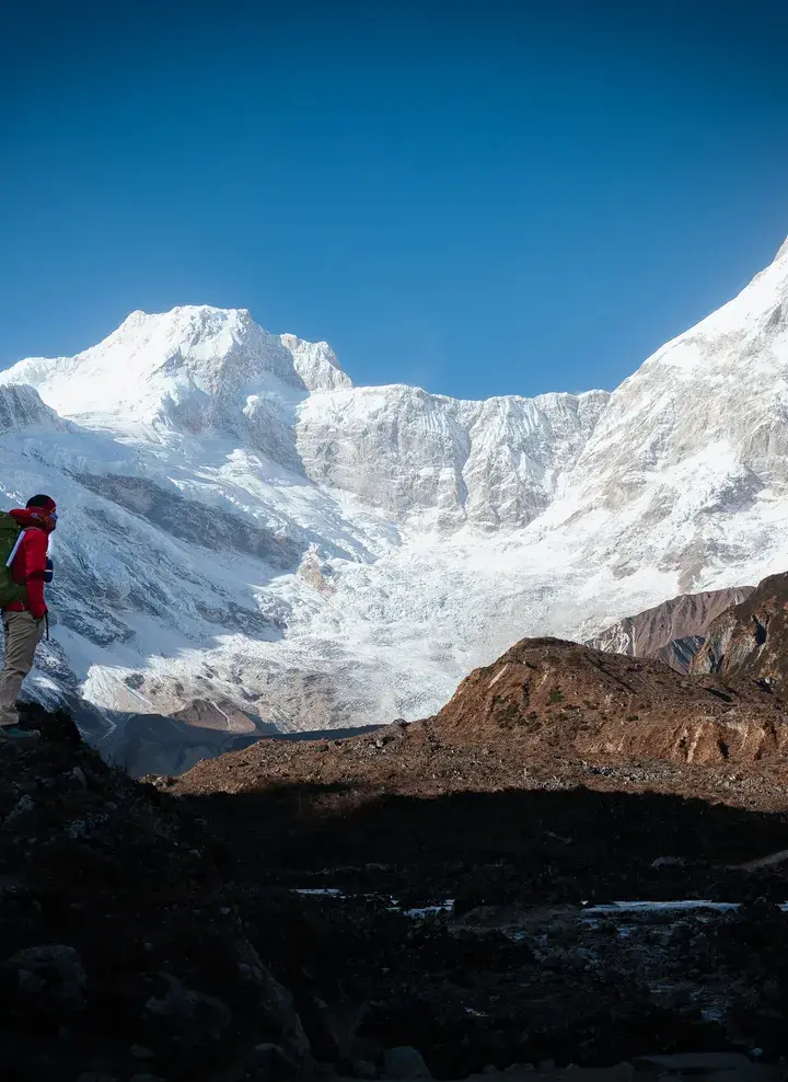 Trekker with backpack overlooking Mount Manaslu in Nepal during a Himalayan trekking adventure.