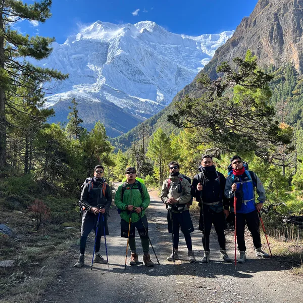 Group of trekkers hiking through forest trail on Annapurna Circuit Trek Nepal